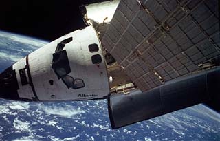 Mir docked to Shuttle over Earth.